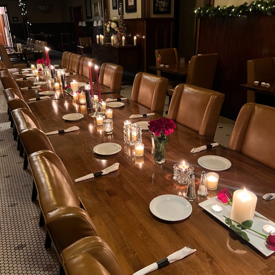Long dining table set with candles and roses